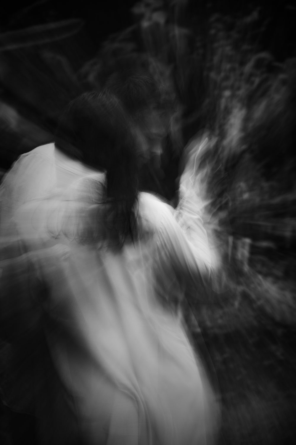 Two dancers in a supported lean, motion-blurred black and white
